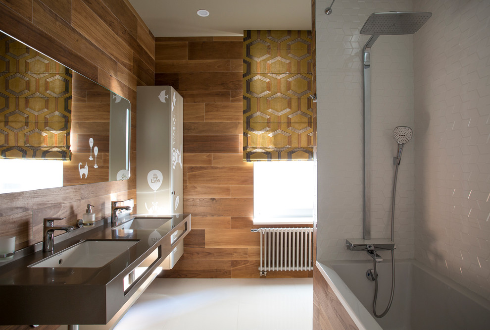 На фото: главная ванная комната в современном стиле с ванной в нише, коричневыми стенами, врезной раковиной и плоскими фасадами