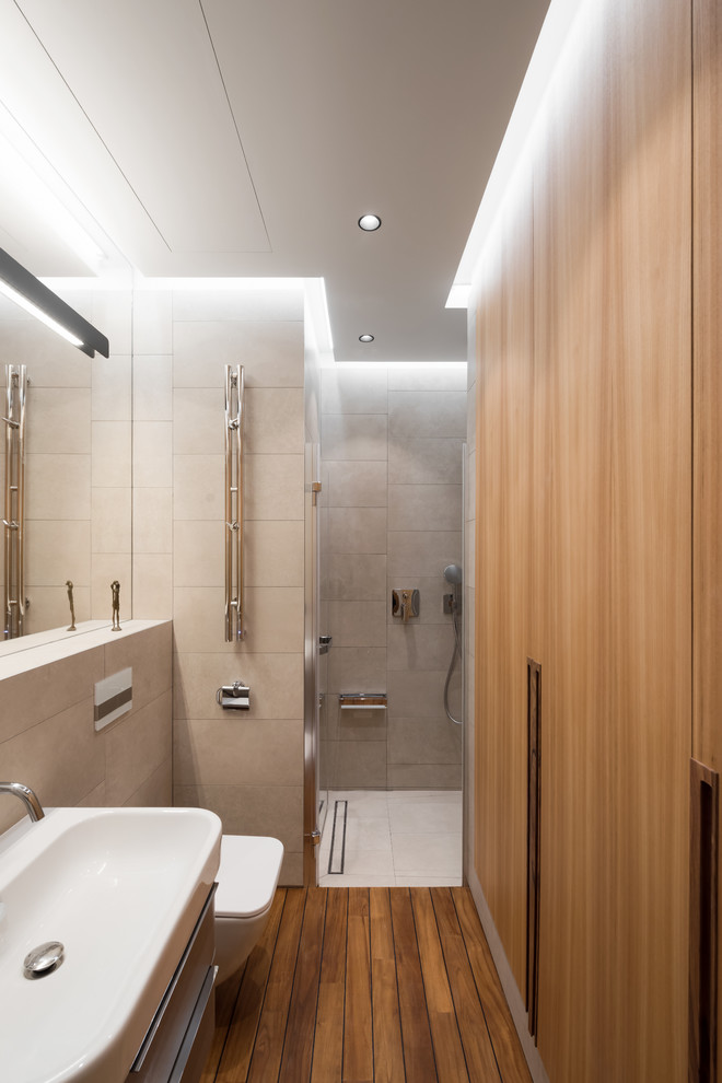 Idéer för att renovera ett litet funkis badrum med dusch, med grå kakel, mellanmörkt trägolv och brunt golv