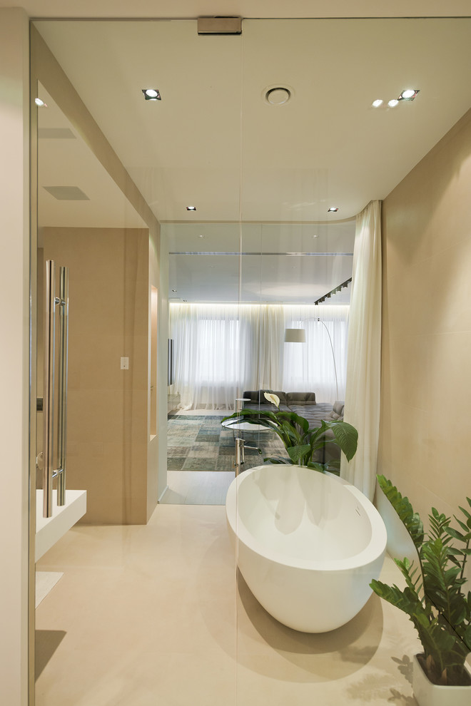 Modelo de cuarto de baño actual con bañera exenta y paredes beige