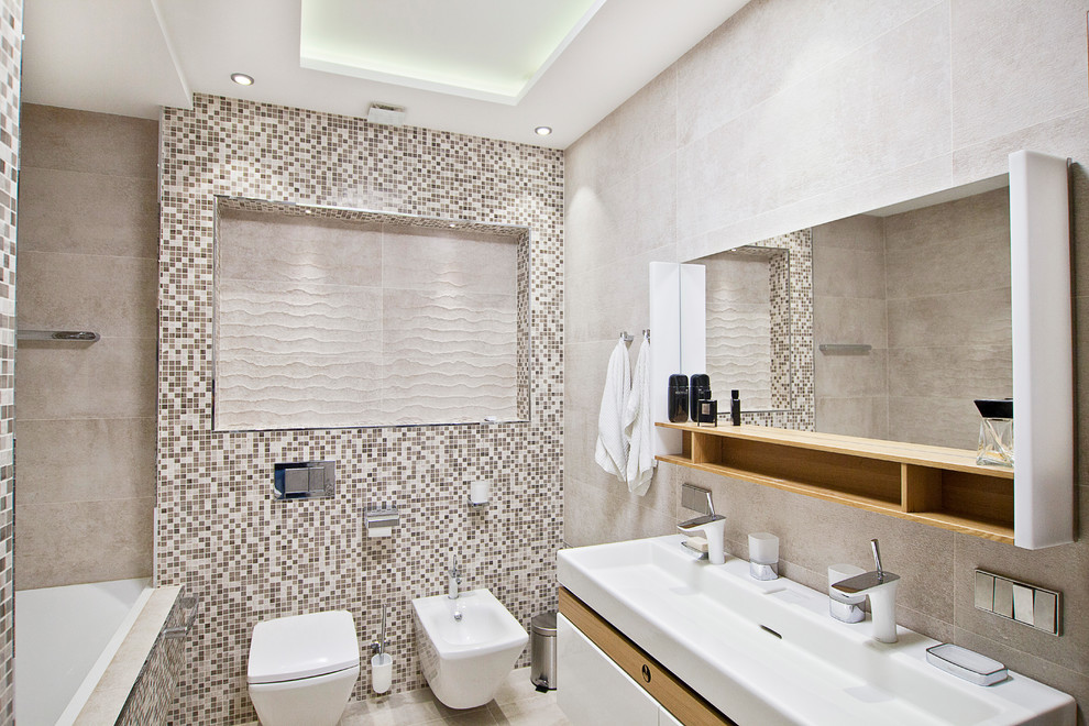 Свежая идея для дизайна: большая главная ванная комната в современном стиле с плоскими фасадами, белыми фасадами, полновстраиваемой ванной, душем в нише, инсталляцией, бежевой плиткой, плиткой мозаикой, бежевыми стенами, полом из керамогранита, раковиной с несколькими смесителями, столешницей из искусственного камня, бежевым полом и душем с распашными дверями - отличное фото интерьера