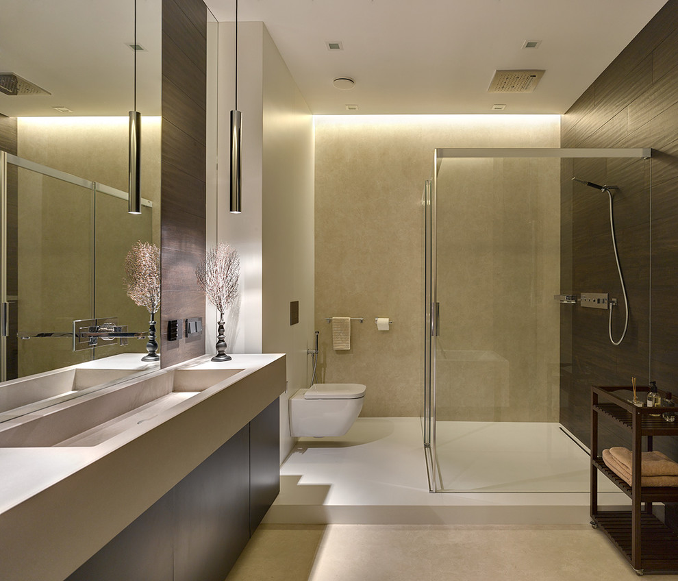 Ejemplo de cuarto de baño contemporáneo con armarios con paneles lisos, sanitario de pared, aseo y ducha, lavabo integrado, baldosas y/o azulejos beige y suelo beige