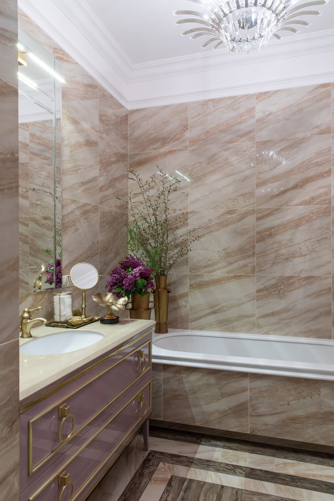 Пример оригинального дизайна: ванная комната в стиле неоклассика (современная классика) с фиолетовыми фасадами, полновстраиваемой ванной, бежевой плиткой, врезной раковиной и разноцветным полом