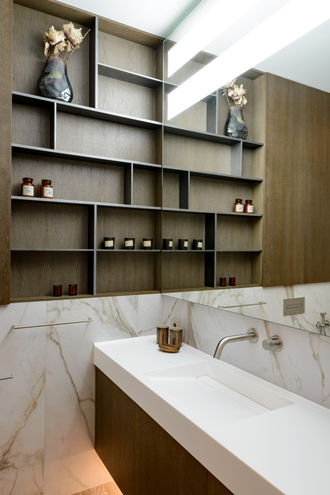 Стильный дизайн: ванная комната в современном стиле с темными деревянными фасадами, монолитной раковиной, плоскими фасадами, разноцветной плиткой, плиткой из листового камня и белой столешницей - последний тренд