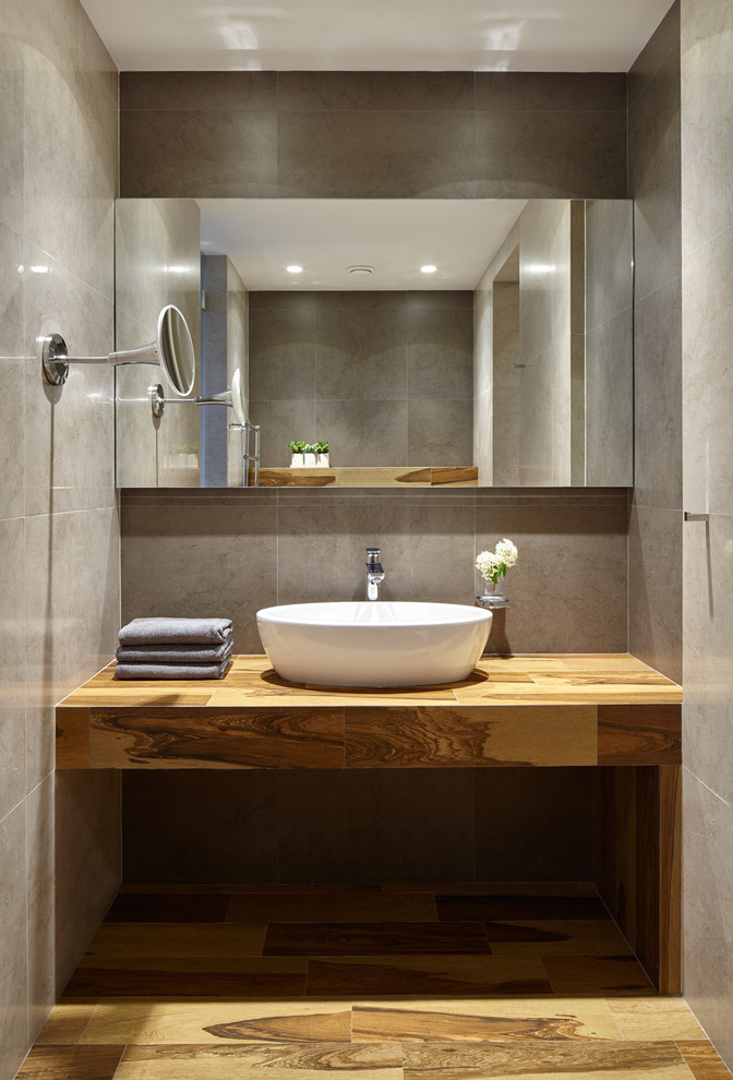 На фото: ванная комната в современном стиле с серой плиткой, серыми стенами и настольной раковиной