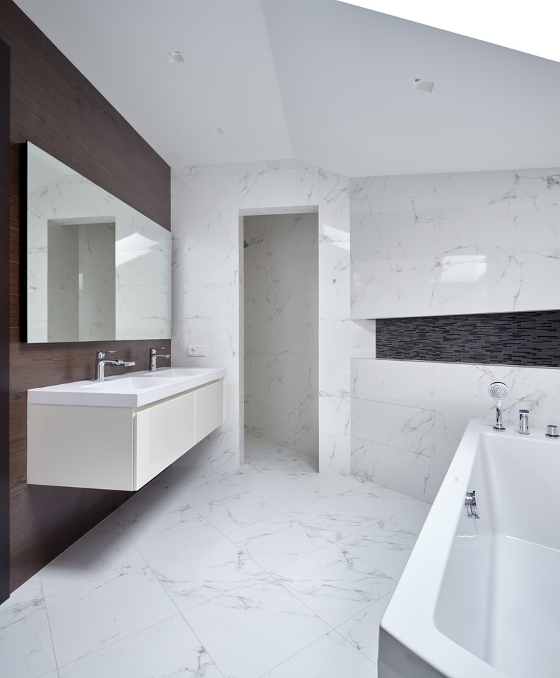 На фото: ванная комната в современном стиле с плоскими фасадами, белыми фасадами, белой плиткой и монолитной раковиной с
