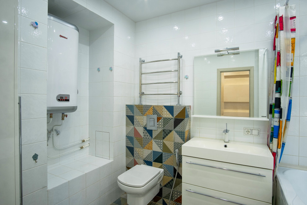 Bild på ett mellanstort funkis vit vitt en-suite badrum, med släta luckor, vita skåp, ett badkar i en alkov, en bidé, vit kakel, keramikplattor, vita väggar och klinkergolv i keramik
