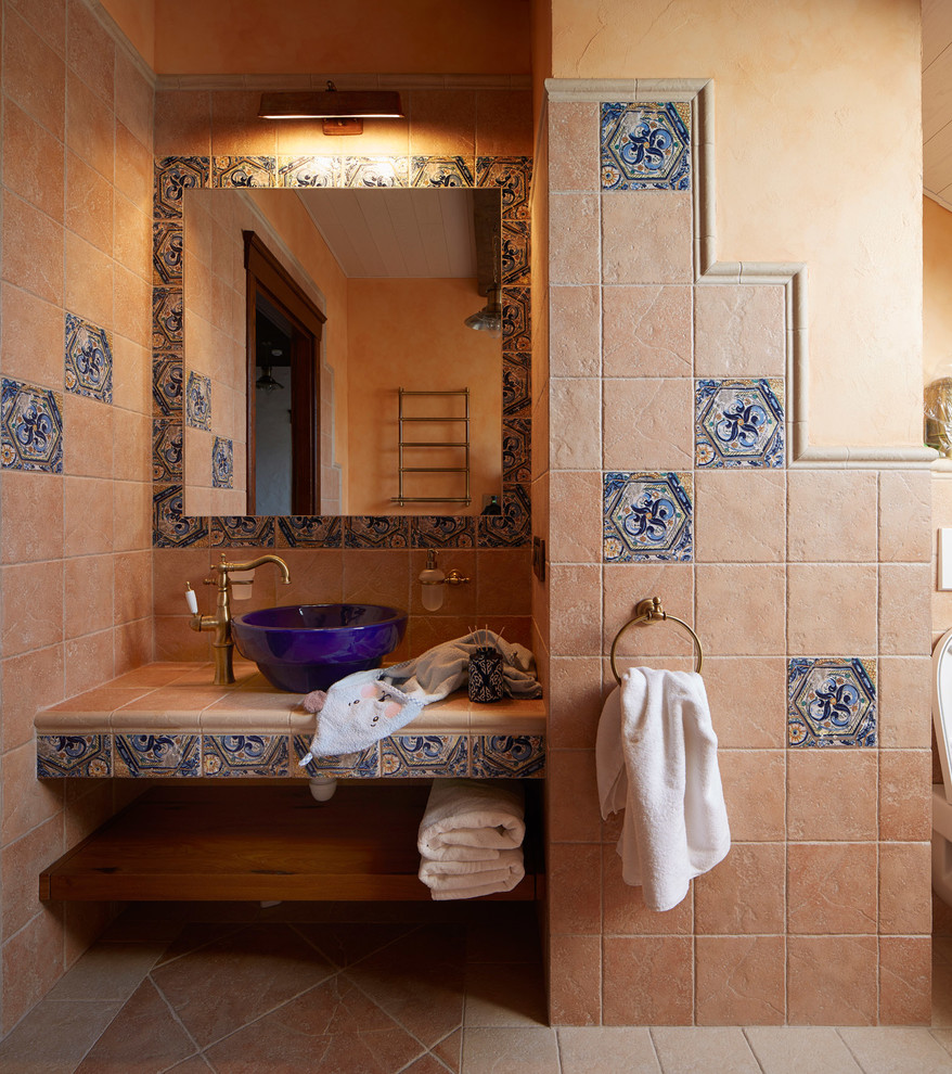 На фото: ванная комната в средиземноморском стиле с бежевой плиткой, бежевыми стенами, настольной раковиной и бежевым полом с