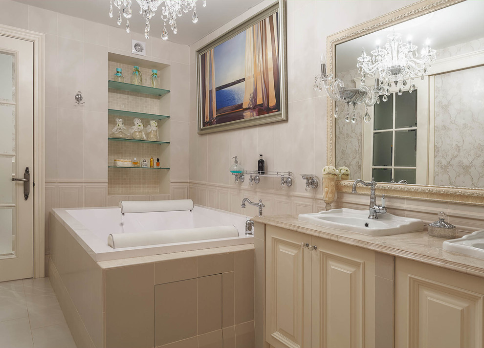 Свежая идея для дизайна: главная ванная комната в классическом стиле с фасадами с выступающей филенкой, бежевыми фасадами, полновстраиваемой ванной, бежевой плиткой, бежевыми стенами и накладной раковиной - отличное фото интерьера
