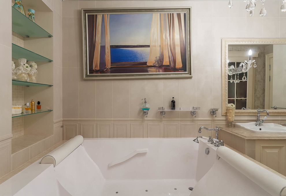 Ispirazione per una stanza da bagno padronale tradizionale con ante con bugna sagomata, ante beige, vasca sottopiano, piastrelle beige, pareti beige e lavabo da incasso