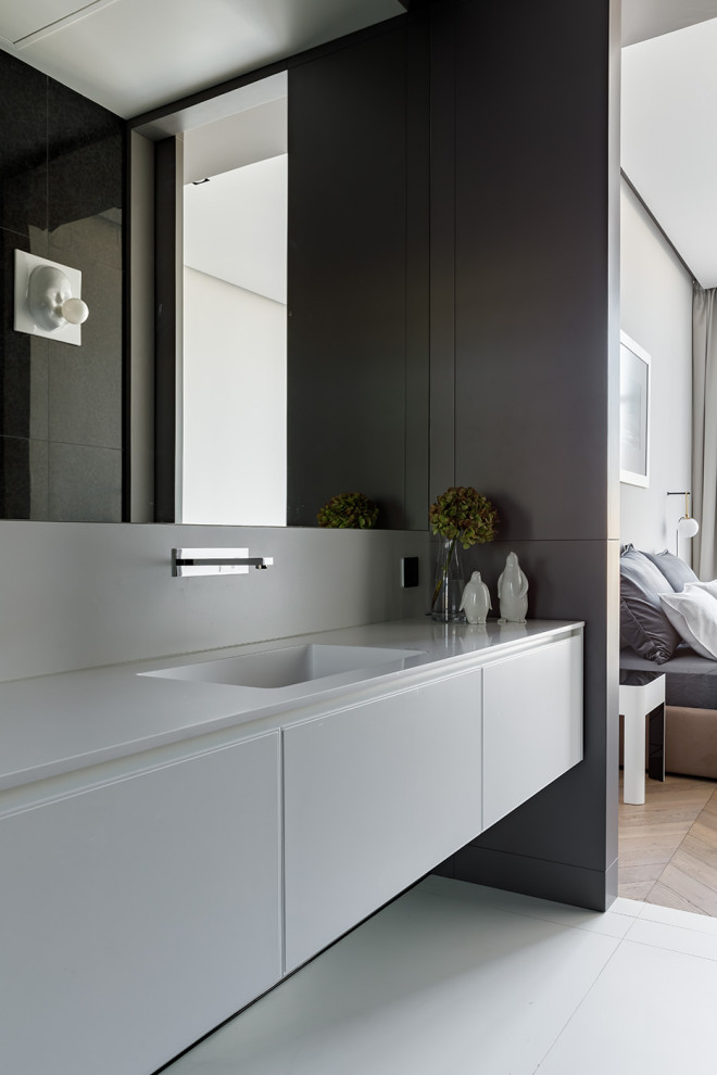 Exemple d'une salle de bain tendance de taille moyenne avec un placard à porte plane, des portes de placard grises, un carrelage gris, un sol en carrelage de porcelaine, un lavabo intégré, un sol gris et un plan de toilette gris.