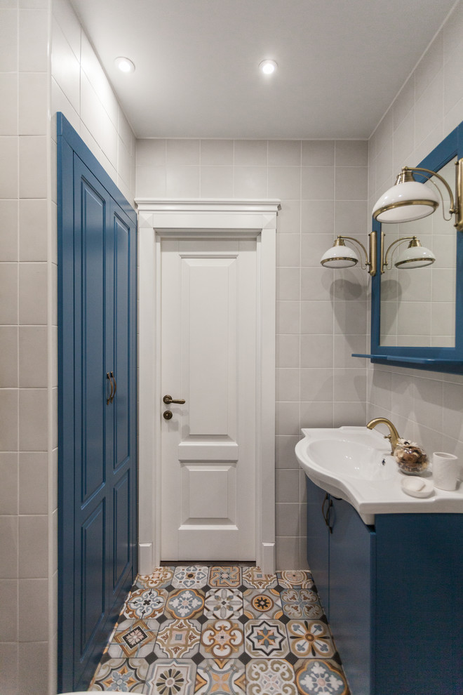 Идея дизайна: маленькая главная ванная комната в стиле кантри с фасадами с утопленной филенкой, ванной в нише, душем над ванной, унитазом-моноблоком, серой плиткой, керамогранитной плиткой, белыми стенами, полом из керамогранита, накладной раковиной, разноцветным полом, шторкой для ванной и белой столешницей для на участке и в саду
