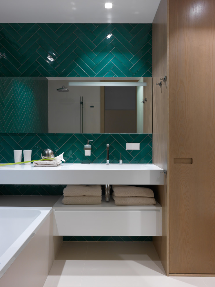 Стильный дизайн: главная ванная комната в современном стиле с белыми фасадами, ванной в нише, зеленой плиткой, белой столешницей, открытыми фасадами и бежевым полом - последний тренд