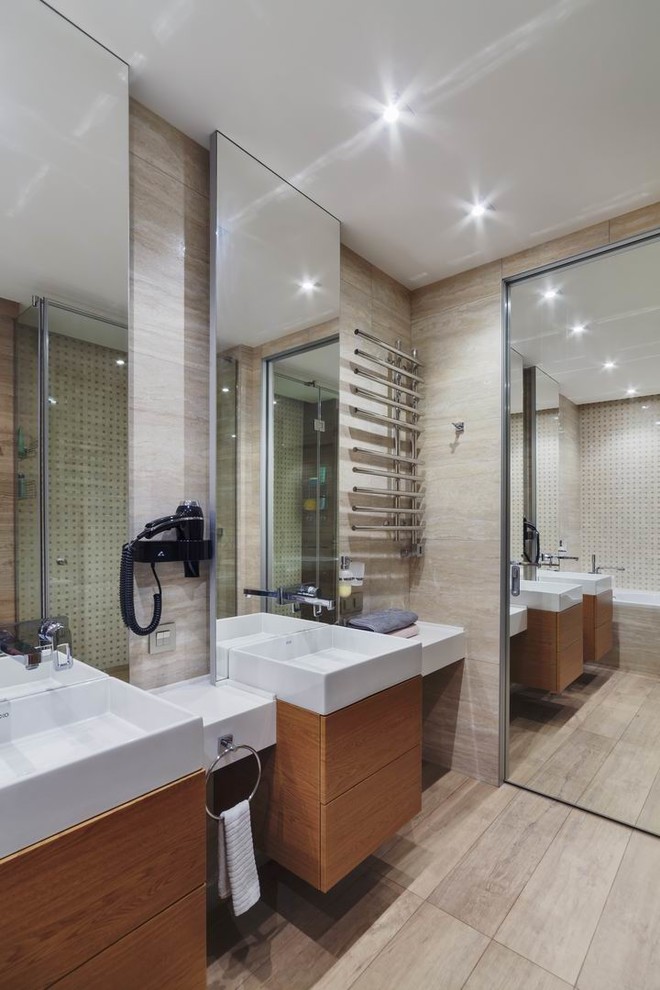 Идея дизайна: ванная комната среднего размера в современном стиле с плоскими фасадами, коричневыми фасадами, ванной в нише, душем в нише, инсталляцией, бежевой плиткой, керамогранитной плиткой, бежевыми стенами, полом из керамогранита, душевой кабиной, накладной раковиной, столешницей из искусственного камня, коричневым полом, душем с распашными дверями и белой столешницей