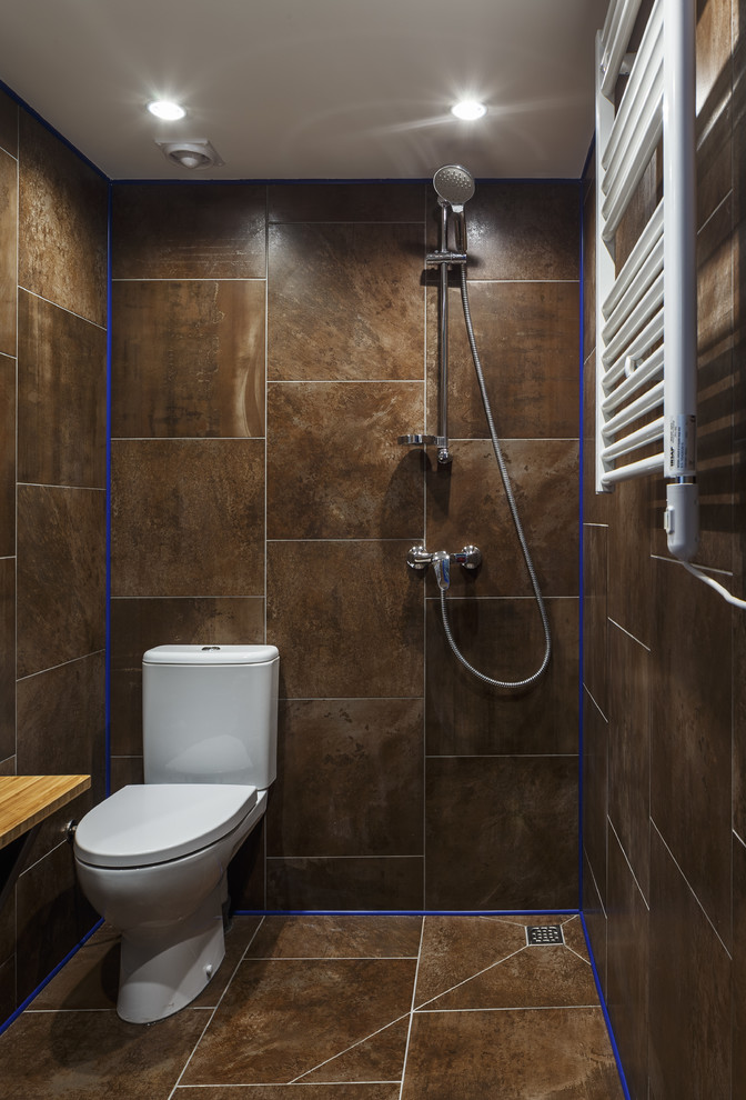 Inredning av ett modernt litet badrum med dusch, med en kantlös dusch, porslinskakel, klinkergolv i porslin, träbänkskiva, med dusch som är öppen, en toalettstol med separat cisternkåpa, brun kakel och brunt golv