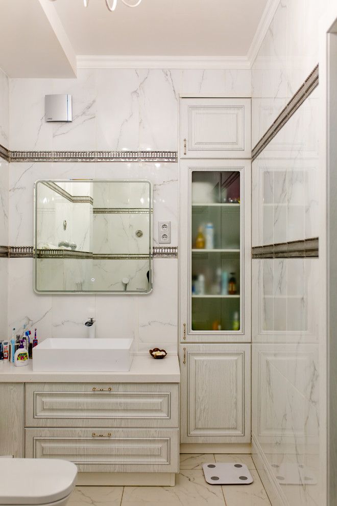 Ejemplo de cuarto de baño tradicional renovado con armarios con paneles con relieve, puertas de armario blancas, baldosas y/o azulejos blancos, lavabo sobreencimera y encimeras blancas