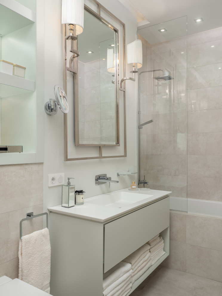 На фото: ванная комната в стиле неоклассика (современная классика) с плоскими фасадами, серыми фасадами, ванной в нише, душем над ванной, инсталляцией, бежевой плиткой, белыми стенами, душевой кабиной, монолитной раковиной, бежевым полом и белой столешницей с