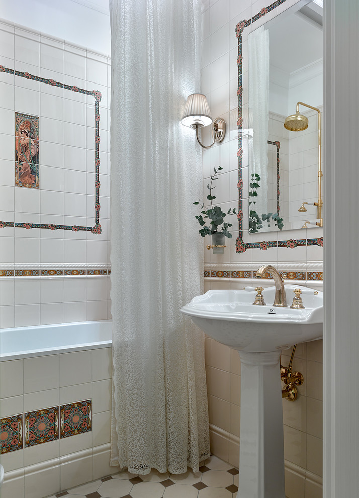 На фото: маленькая главная ванная комната в классическом стиле с раковиной с пьедесталом, шторкой для ванной, накладной ванной, бежевой плиткой, разноцветной плиткой, разноцветным полом и зеркалом с подсветкой для на участке и в саду