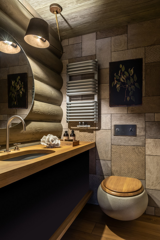 Идея дизайна: ванная комната в стиле кантри с инсталляцией, серой плиткой, врезной раковиной, столешницей из дерева, плоскими фасадами и фасадами цвета дерева среднего тона