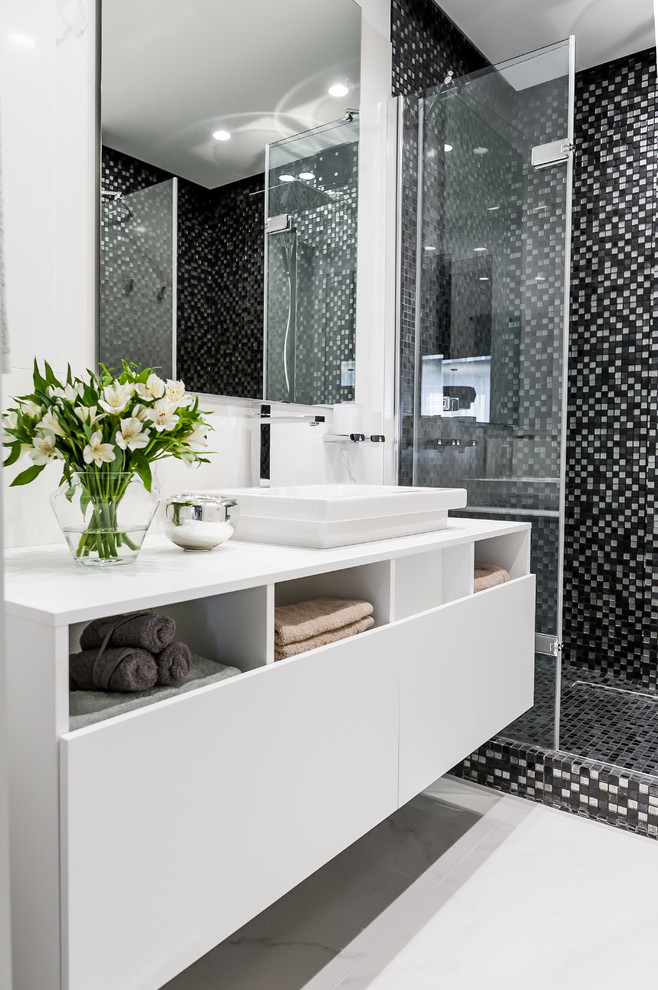 На фото: ванная комната в современном стиле с плоскими фасадами, белыми фасадами, душем в нише, белой плиткой, черно-белой плиткой, плиткой мозаикой, душевой кабиной, белым полом, душем с распашными дверями и настольной раковиной с