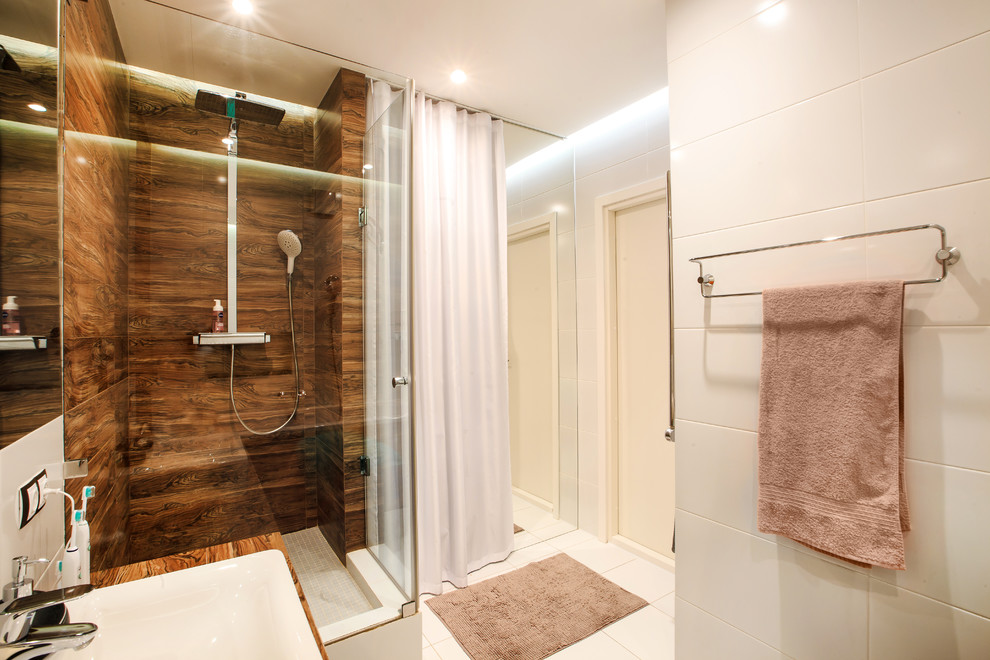 Modelo de cuarto de baño blanco y madera actual con baldosas y/o azulejos blancos, paredes blancas, lavabo encastrado, ducha empotrada y suelo de baldosas de cerámica