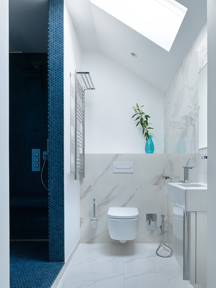 Foto de cuarto de baño contemporáneo con ducha empotrada, sanitario de pared, paredes blancas, aseo y ducha, lavabo integrado y suelo blanco