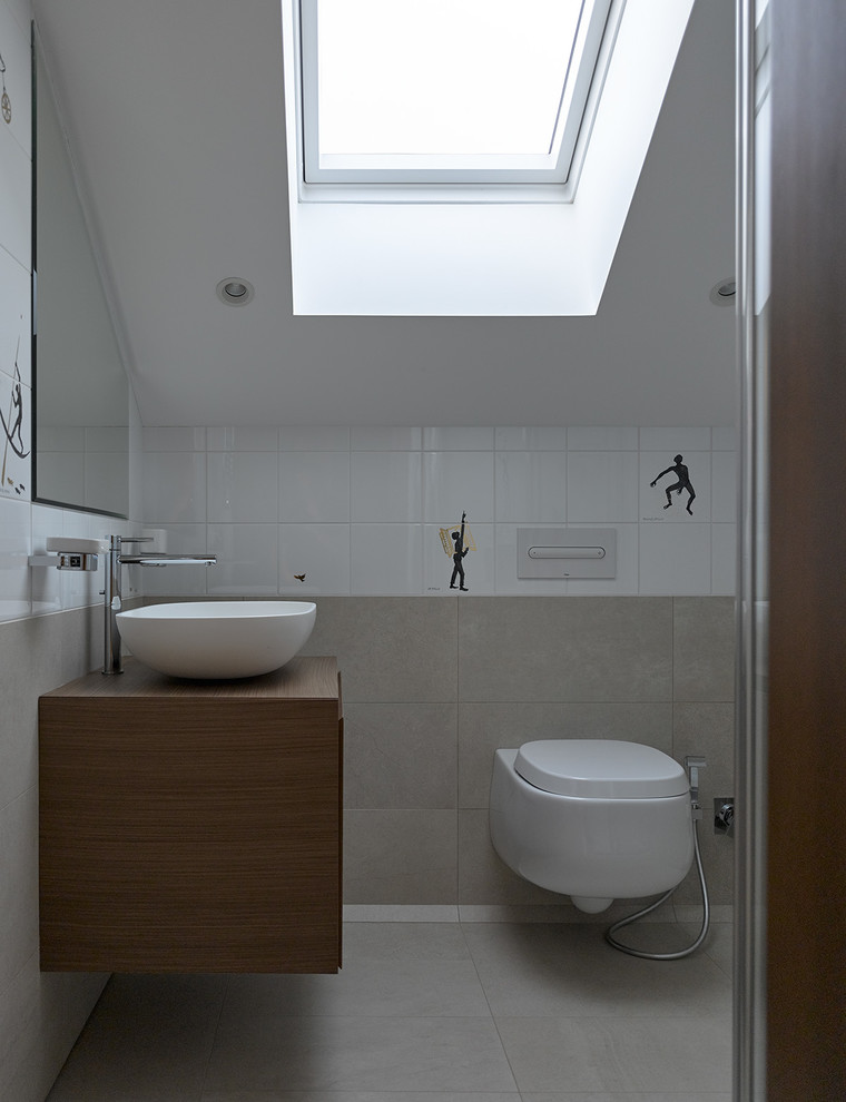 На фото: детская ванная комната в современном стиле с плоскими фасадами, инсталляцией, белой плиткой, серой плиткой, настольной раковиной и серым полом