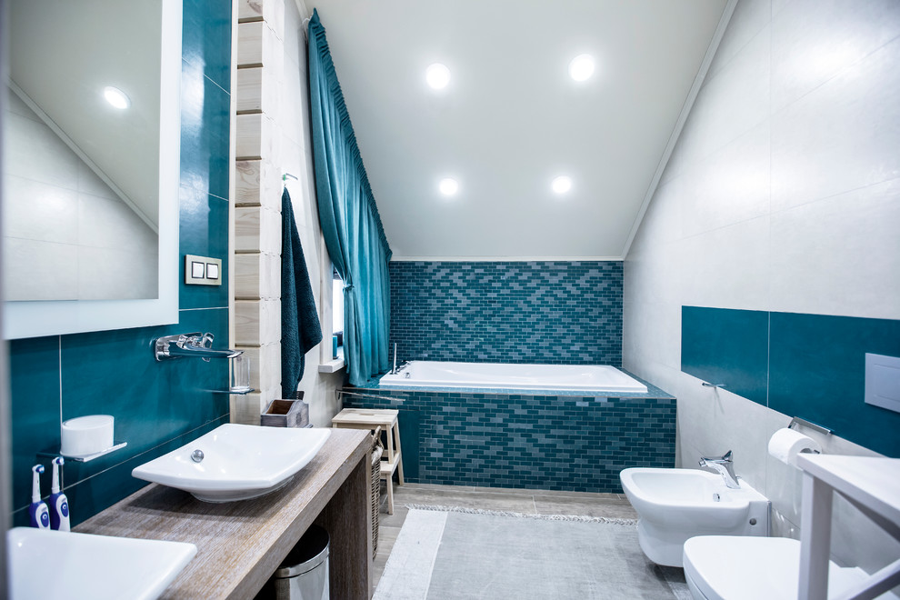 Ispirazione per una stanza da bagno padronale classica con vasca ad alcova, piastrelle blu, piastrelle bianche e lavabo a bacinella