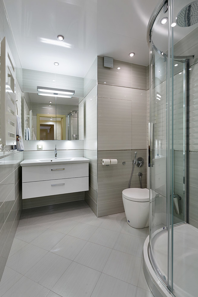 На фото: ванная комната среднего размера в современном стиле с угловым душем, раздельным унитазом, серой плиткой, керамической плиткой, серыми стенами, полом из керамической плитки, душевой кабиной, подвесной раковиной, белым полом и душем с раздвижными дверями с