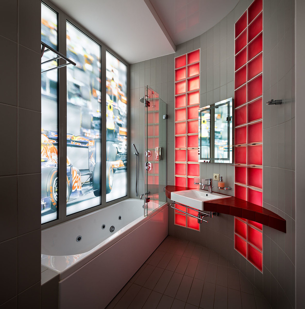 Exemple d'une salle de bain principale tendance en bois foncé avec un placard sans porte, un combiné douche/baignoire, un carrelage gris, un lavabo intégré, une baignoire posée, un mur beige et aucune cabine.