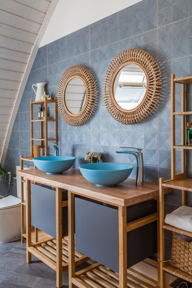 Immagine di una stanza da bagno bohémian con piastrelle grigie, pareti bianche, lavabo a bacinella, top in legno, pavimento grigio, ante lisce e top marrone