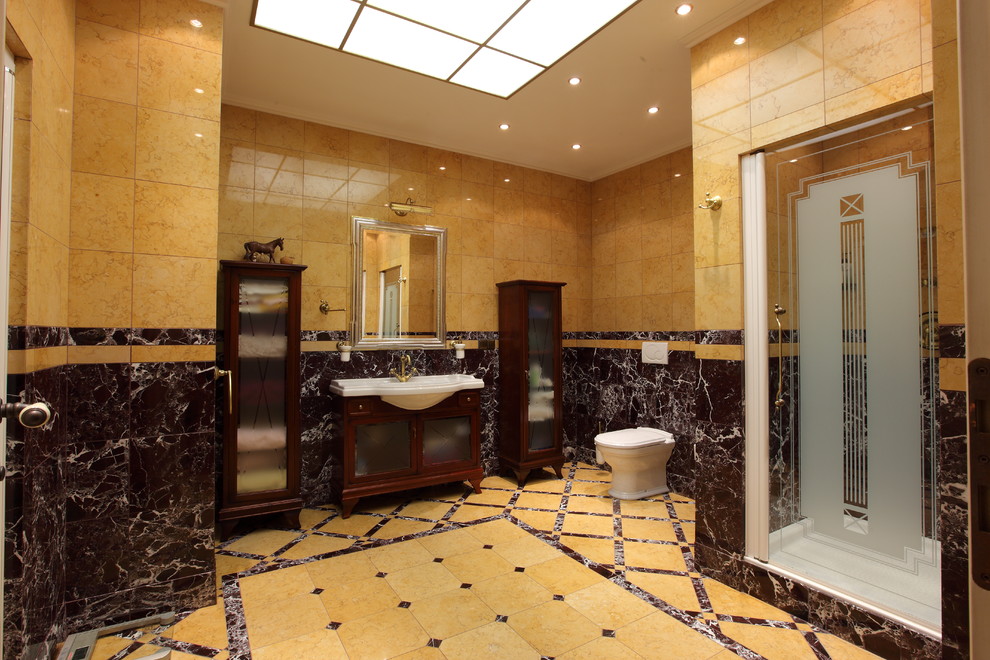 Aménagement d'une salle de bain principale classique en bois foncé avec une douche d'angle, WC suspendus, un carrelage beige, un lavabo suspendu, une cabine de douche à porte battante et un placard avec porte à panneau encastré.
