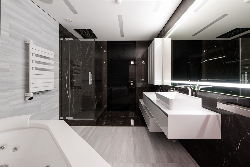 Стильный дизайн: главная ванная комната в современном стиле с плоскими фасадами, белыми фасадами, гидромассажной ванной, угловым душем, серой плиткой, черной плиткой, настольной раковиной, душем с распашными дверями и зеркалом с подсветкой - последний тренд