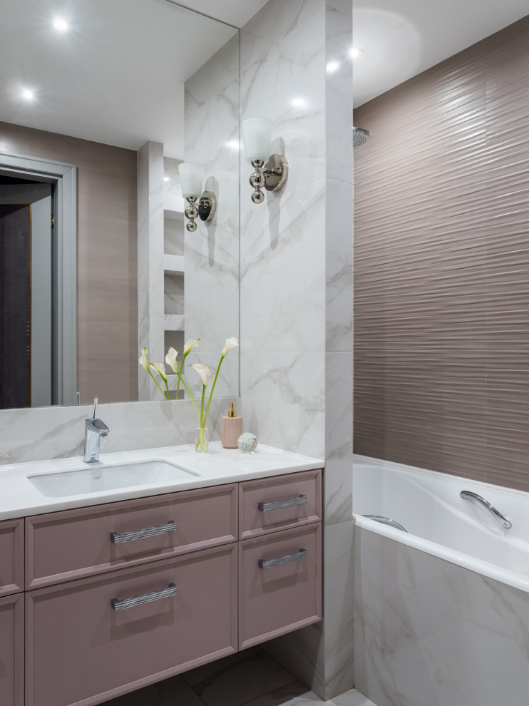 This is an example of a medium sized contemporary shower room bathroom in Other with recessed-panel cabinets, an alcove bath, a shower/bath combination, pink tiles, a submerged sink, grey floors, white worktops, a single sink and a floating vanity unit.
