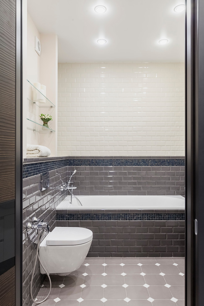 Inspiration pour une salle de bain principale traditionnelle de taille moyenne avec une baignoire en alcôve, un combiné douche/baignoire, WC suspendus, un carrelage gris, un carrelage blanc, un carrelage métro, un sol en carrelage de céramique et un sol gris.