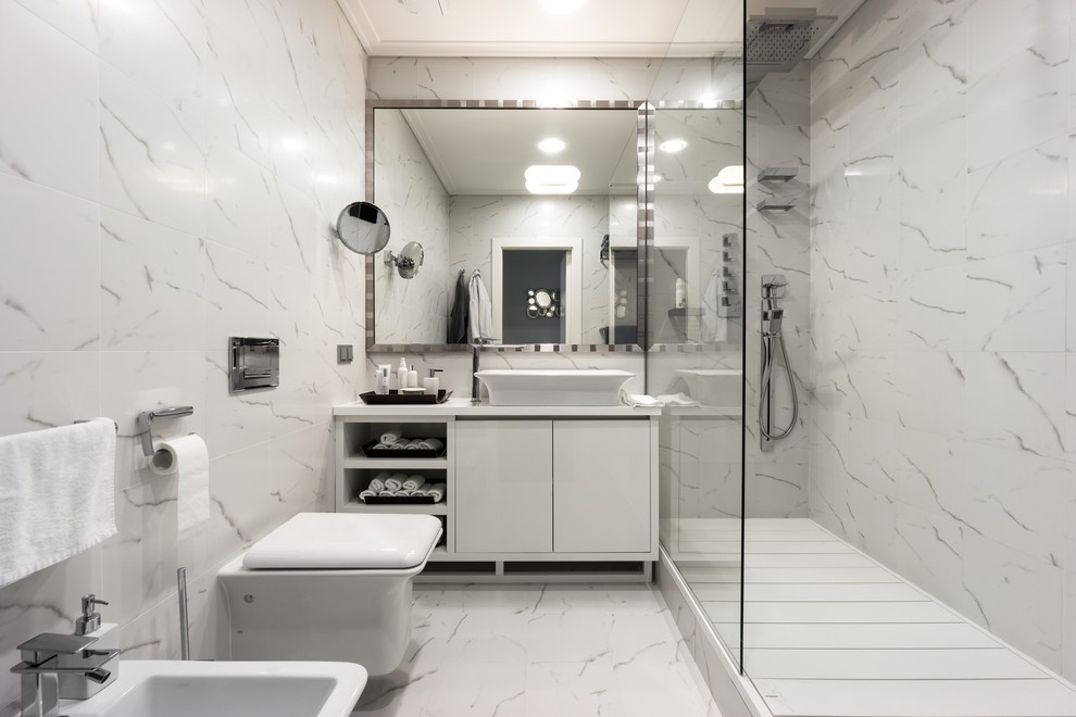Inspiration för moderna badrum med dusch, med släta luckor, vita skåp, en dusch i en alkov, en bidé, vit kakel, marmorgolv och ett fristående handfat