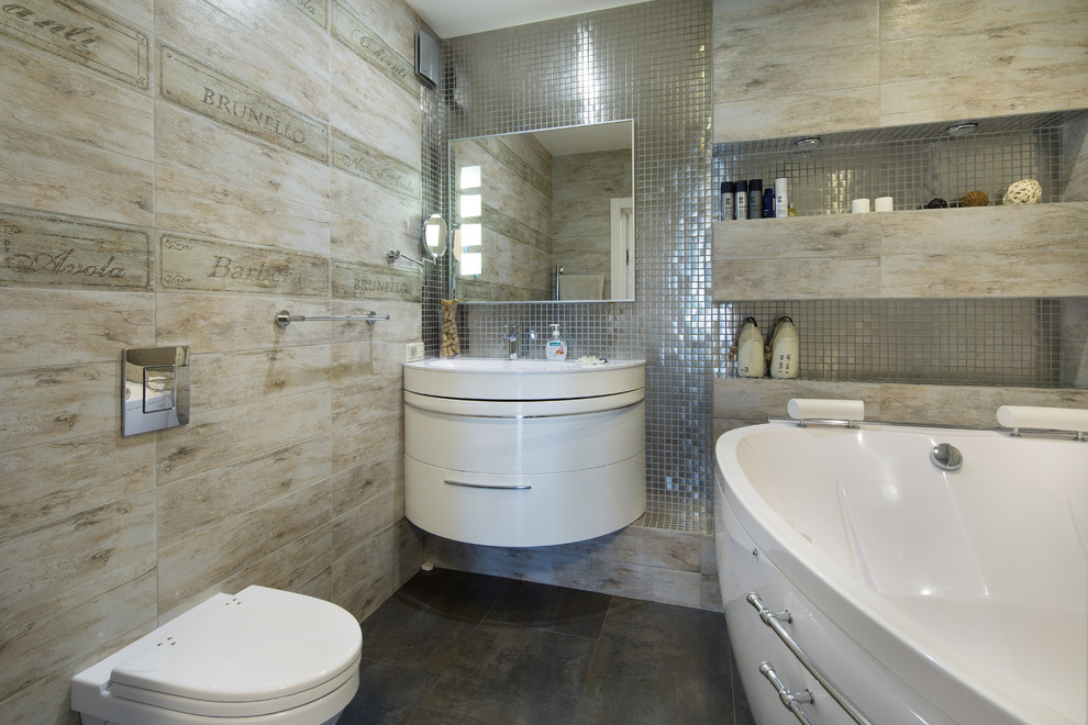 Modelo de cuarto de baño contemporáneo con bañera empotrada, lavabo integrado, puertas de armario blancas, sanitario de pared, baldosas y/o azulejos beige y suelo marrón