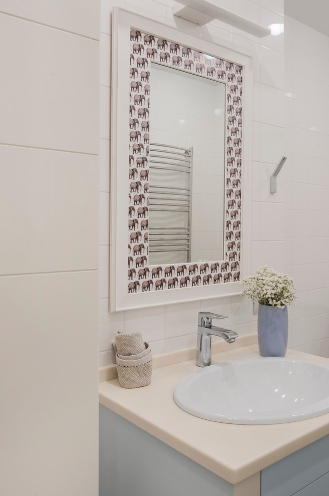 Foto di una stanza da bagno design con ante lisce, ante beige, piastrelle bianche, piastrelle in ceramica, top beige e un lavabo