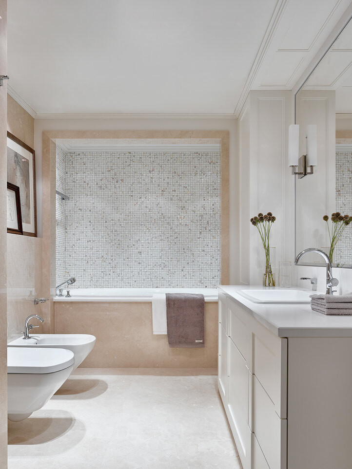 На фото: главная ванная комната в стиле неоклассика (современная классика) с белыми фасадами, ванной в нише, инсталляцией, бежевой плиткой, накладной раковиной и белым полом с