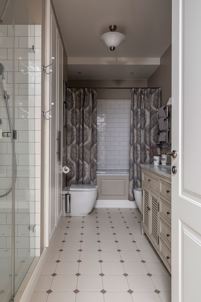 Klassisk inredning av ett stort badrum, med ett badkar i en alkov, en dusch i en alkov, en vägghängd toalettstol, vit kakel, keramikplattor, grå väggar, klinkergolv i keramik, grått golv och dusch med gångjärnsdörr