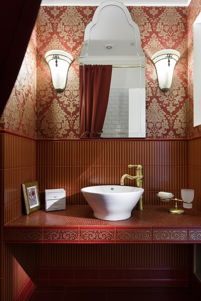 Cette photo montre une salle de bain chic avec un carrelage rouge, un mur rouge, une vasque, un plan de toilette en carrelage et un placard sans porte.