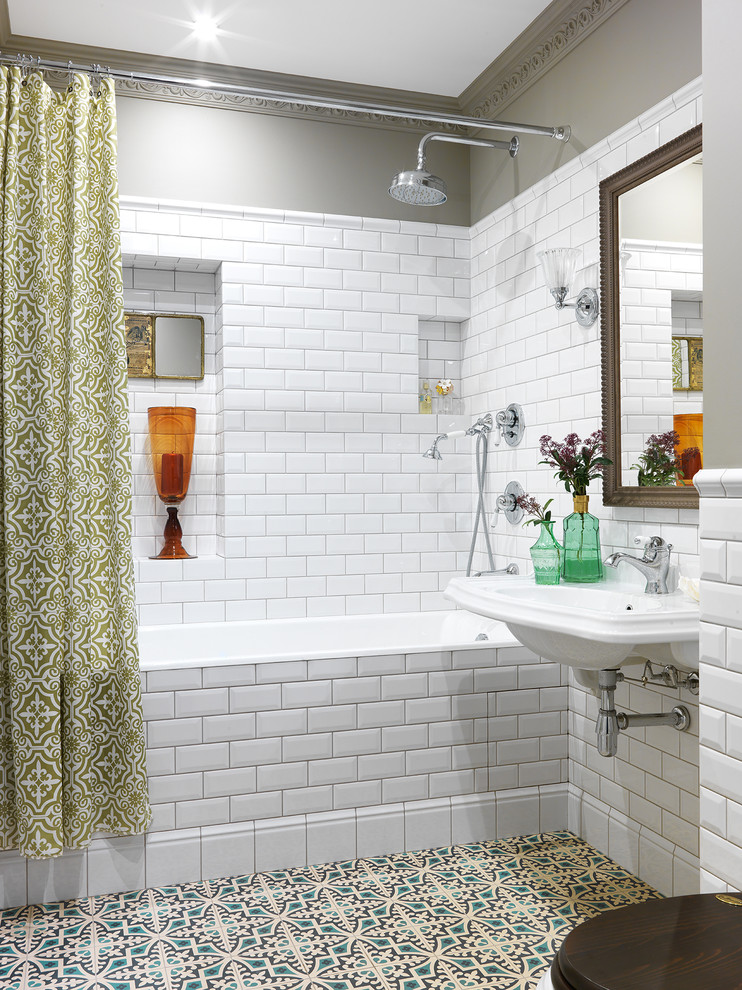 Klassisk inredning av ett en-suite badrum, med ett badkar i en alkov, en dusch/badkar-kombination, vit kakel, tunnelbanekakel, grå väggar, ett väggmonterat handfat, flerfärgat golv och dusch med duschdraperi