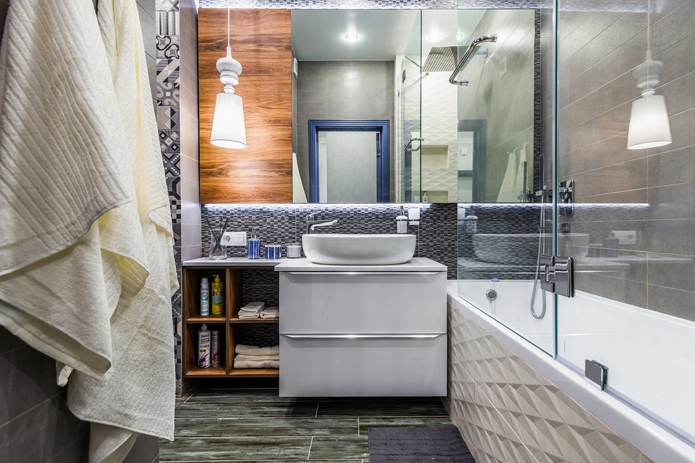 На фото: главная ванная комната в современном стиле с плоскими фасадами, белыми фасадами, накладной ванной, душем над ванной, серой плиткой, настольной раковиной, серым полом, душем с раздвижными дверями и серой столешницей с