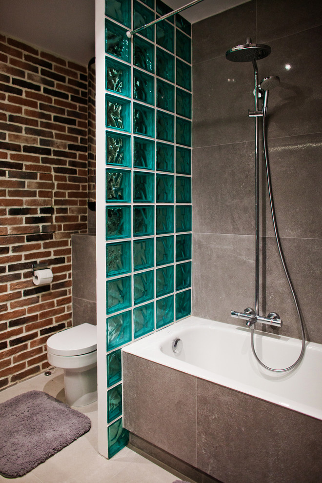Cette image montre une salle de bain principale urbaine avec une baignoire en alcôve, un combiné douche/baignoire, WC séparés, un carrelage gris, un mur marron et une cabine de douche avec un rideau.