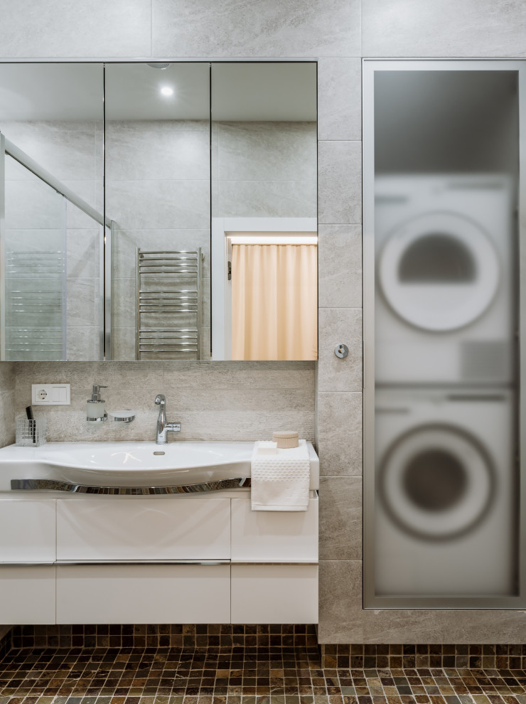Idéer för att renovera ett mellanstort funkis vit vitt badrum med dusch, med släta luckor, vita skåp, en dusch i en alkov, grå kakel, porslinskakel, ett integrerad handfat, brunt golv och dusch med skjutdörr