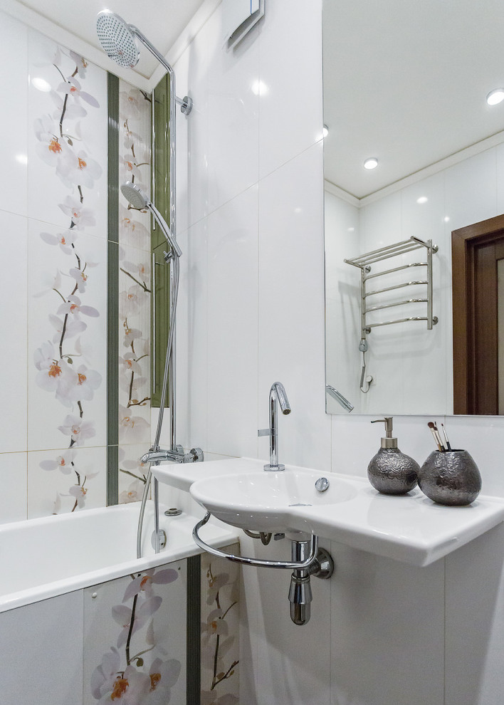 Modelo de cuarto de baño principal actual pequeño con baldosas y/o azulejos blancos, baldosas y/o azulejos de cerámica, suelo de baldosas de porcelana, lavabo suspendido, bañera empotrada y combinación de ducha y bañera