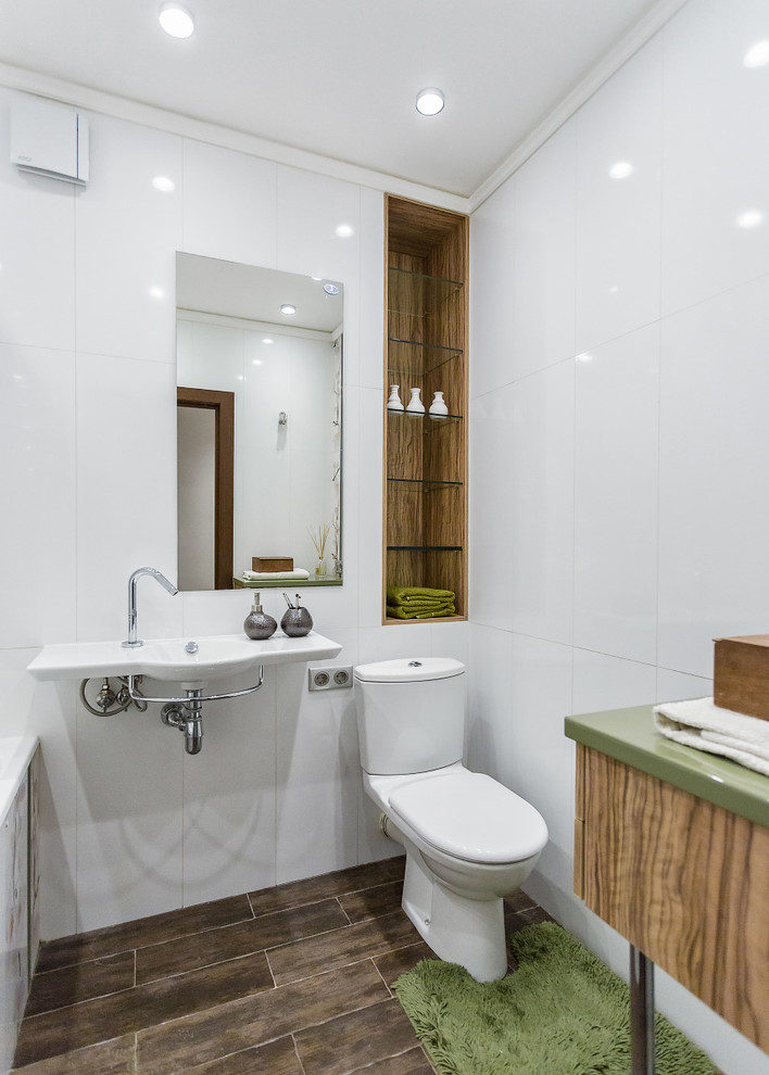 Kleines Modernes Badezimmer En Suite mit Badewanne in Nische, Wandtoilette mit Spülkasten, weißen Fliesen, Wandwaschbecken, weißer Wandfarbe und braunem Holzboden in Moskau