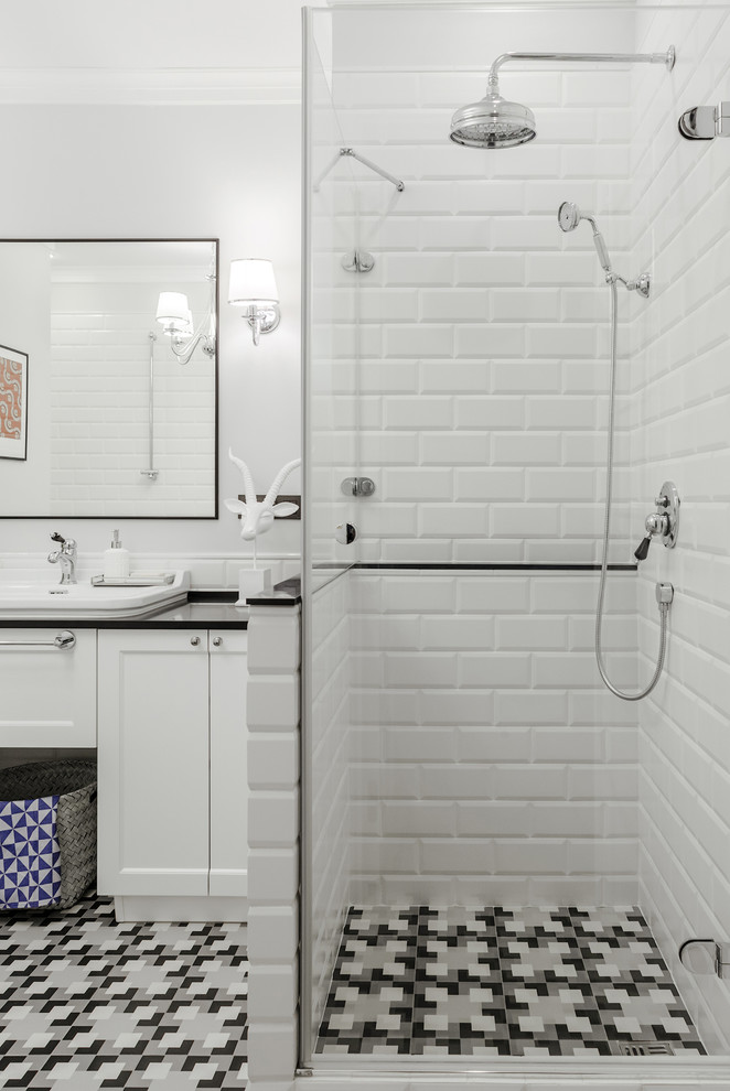 Идея дизайна: ванная комната среднего размера в стиле неоклассика (современная классика) с фасадами с утопленной филенкой, белыми фасадами, душем в нише, белой плиткой, керамической плиткой, серыми стенами, полом из керамической плитки, накладной раковиной, столешницей из искусственного камня, разноцветным полом, душем с распашными дверями, черной столешницей и душевой кабиной