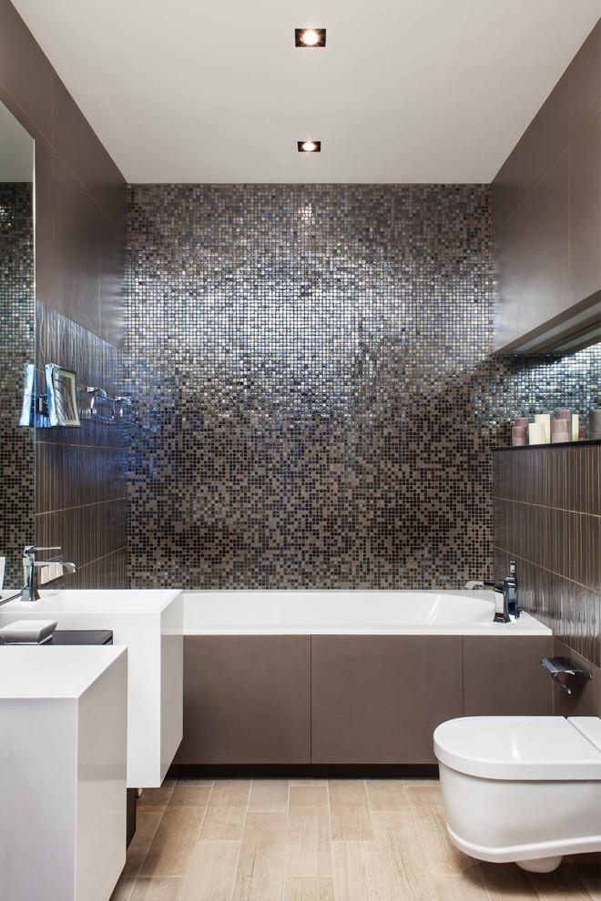 На фото: главная ванная комната в современном стиле с ванной в нише, инсталляцией, коричневой плиткой, плоскими фасадами, белыми фасадами и плиткой мозаикой