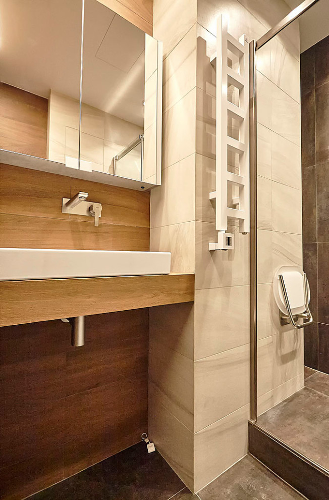 Foto på ett mellanstort funkis vit badrum med dusch, med vita skåp, en dusch i en alkov, en vägghängd toalettstol, brun kakel, porslinskakel, bruna väggar, klinkergolv i porslin, ett nedsänkt handfat, bänkskiva i akrylsten, brunt golv, dusch med gångjärnsdörr och luckor med glaspanel