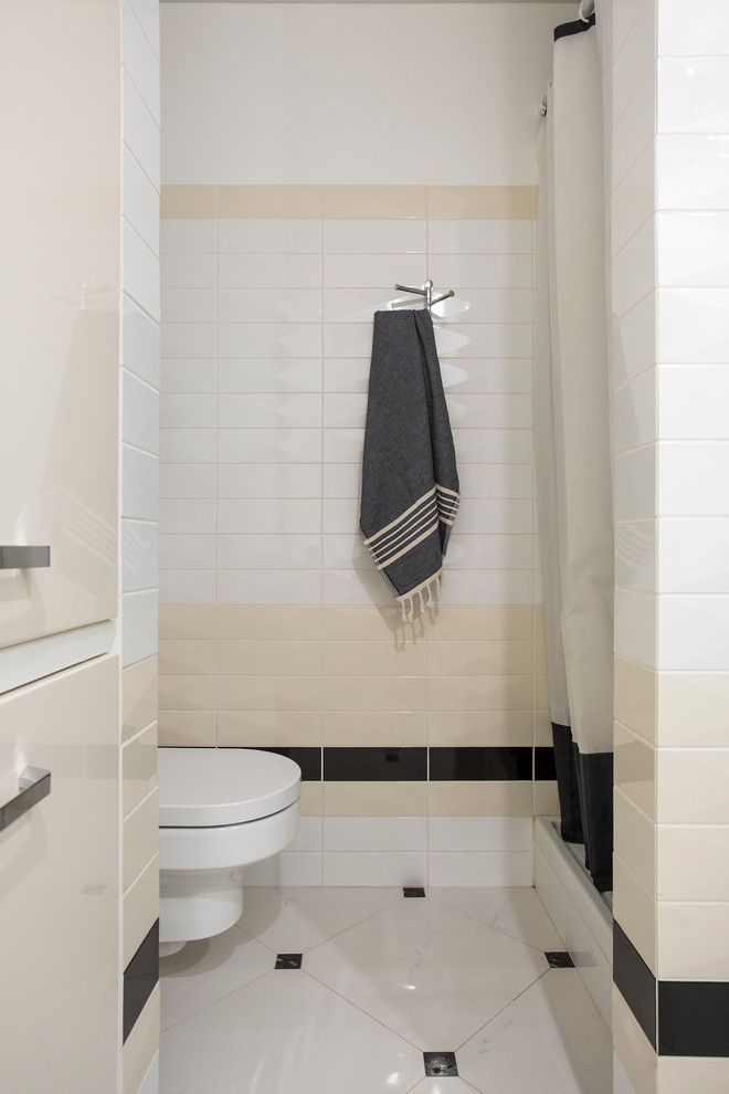 Réalisation d'une salle de bain design avec WC suspendus, un sol en carrelage de porcelaine, un carrelage beige, un carrelage blanc, un carrelage noir et une cabine de douche avec un rideau.